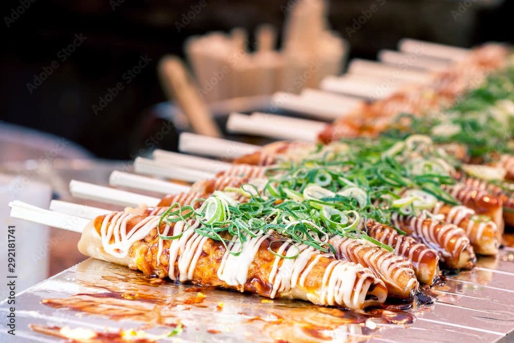 Food wrapped in banana leaves grilling over open coals